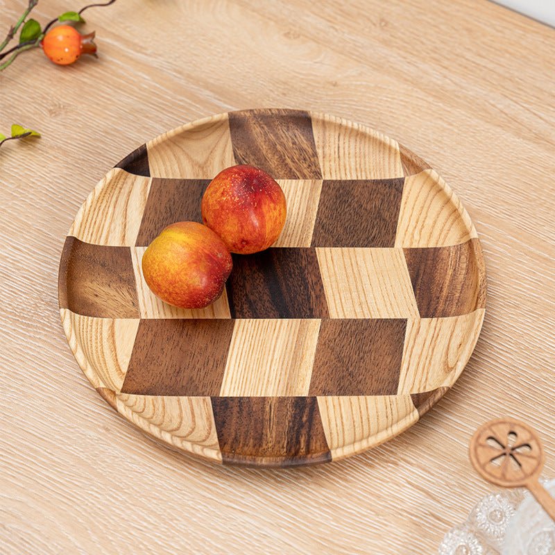 Round acacia wood serving plate displaying a fresh layer cake.