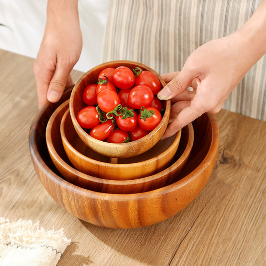 Hand-painted round wooden bowl filled with fresh garden salad.