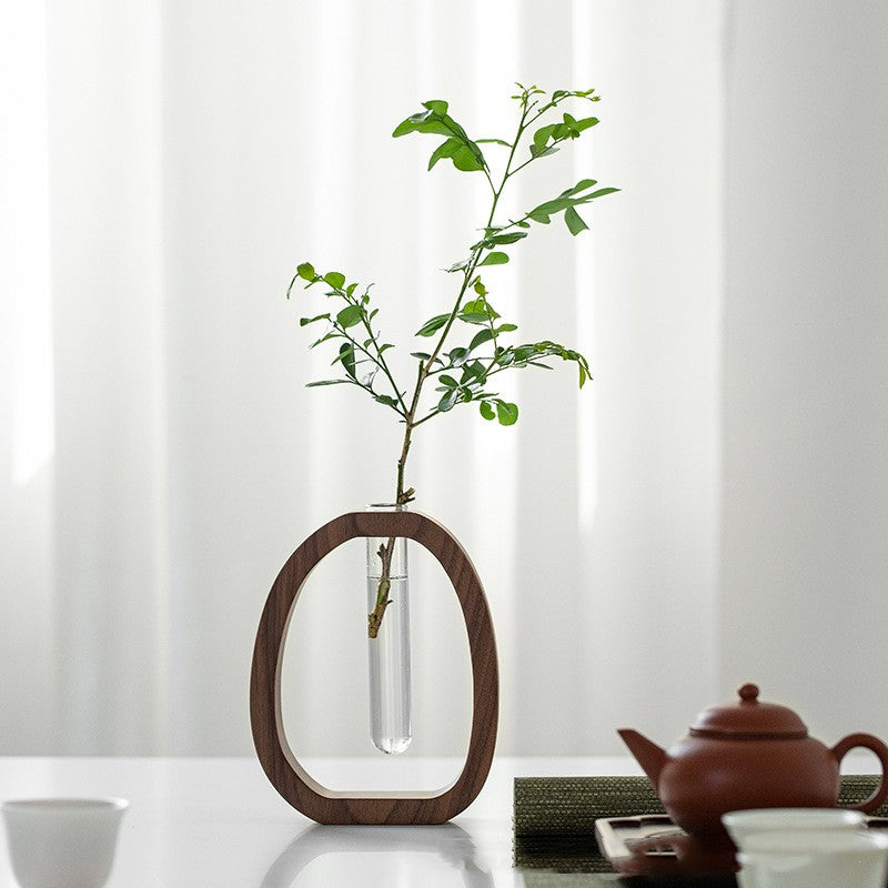Handcrafted solid walnut wood flower vase on a minimalist wooden table.
