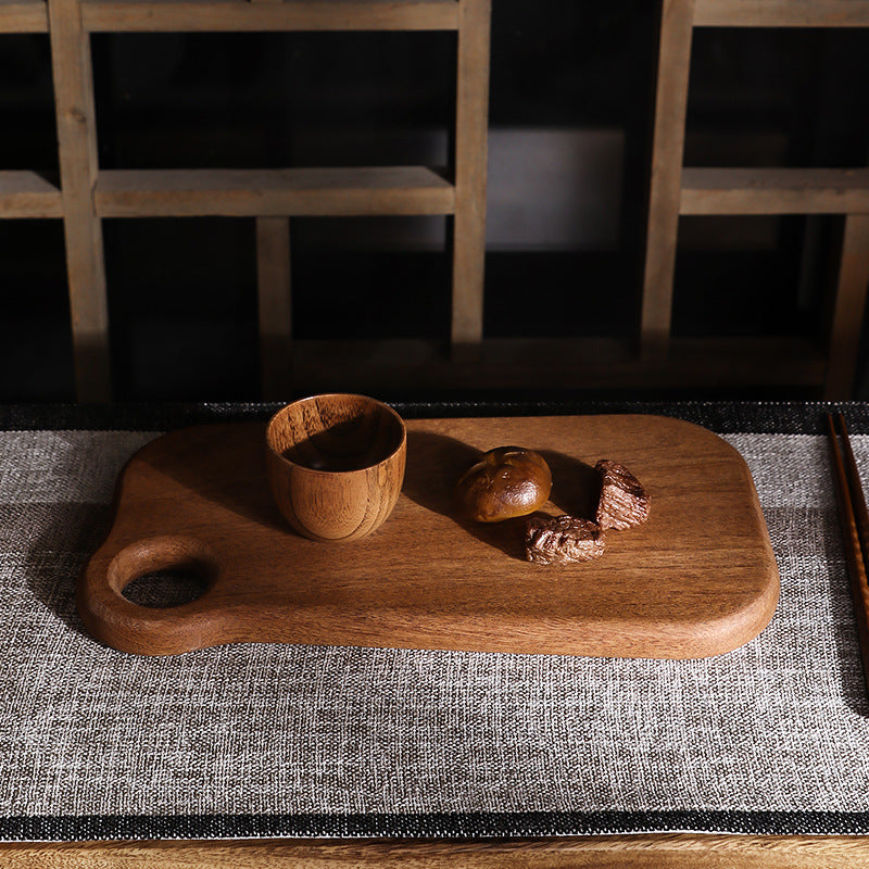 Premium dark ebony wood cutting board with an irregular organic shape.