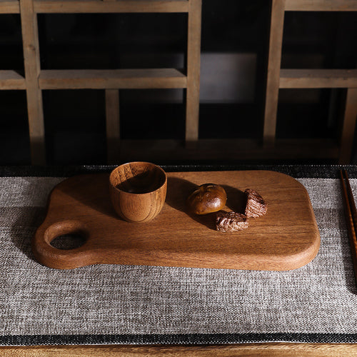 Premium dark ebony wood cutting board with an irregular organic shape.